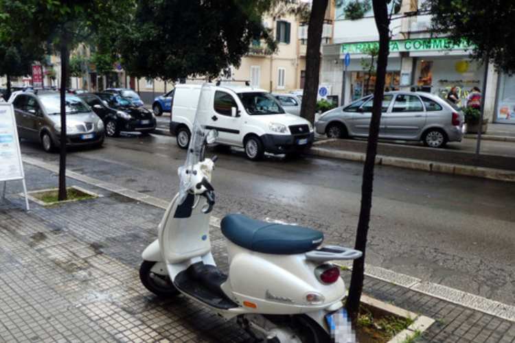 Scooter parcheggiato sul marciapiede con adesivi o decalcomanie